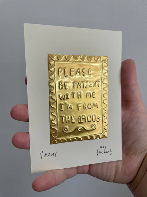 Hand holding a card with a gold embossed message on a plain background available at kolab concept store 